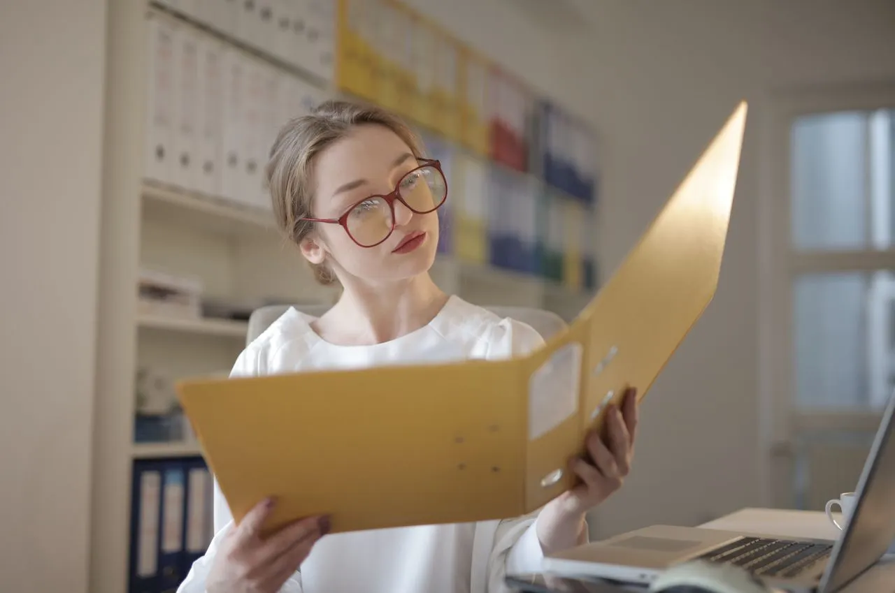 An office administrator reviewing invoices on a laptop