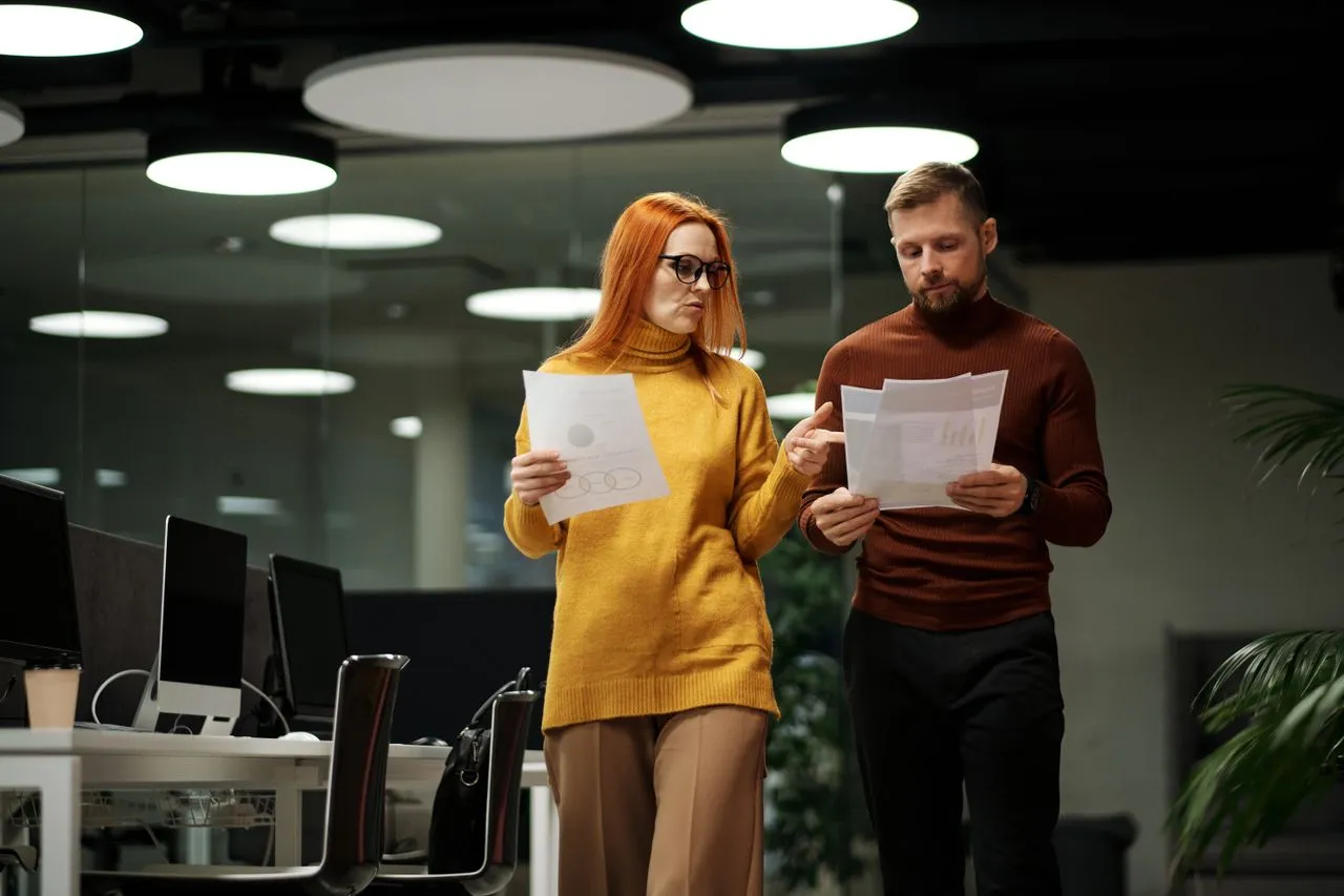 Two office staff reviewing invoices together
